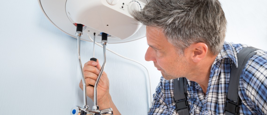 Close-up Of Mid-adult Male Plumber Repairing Water Heater